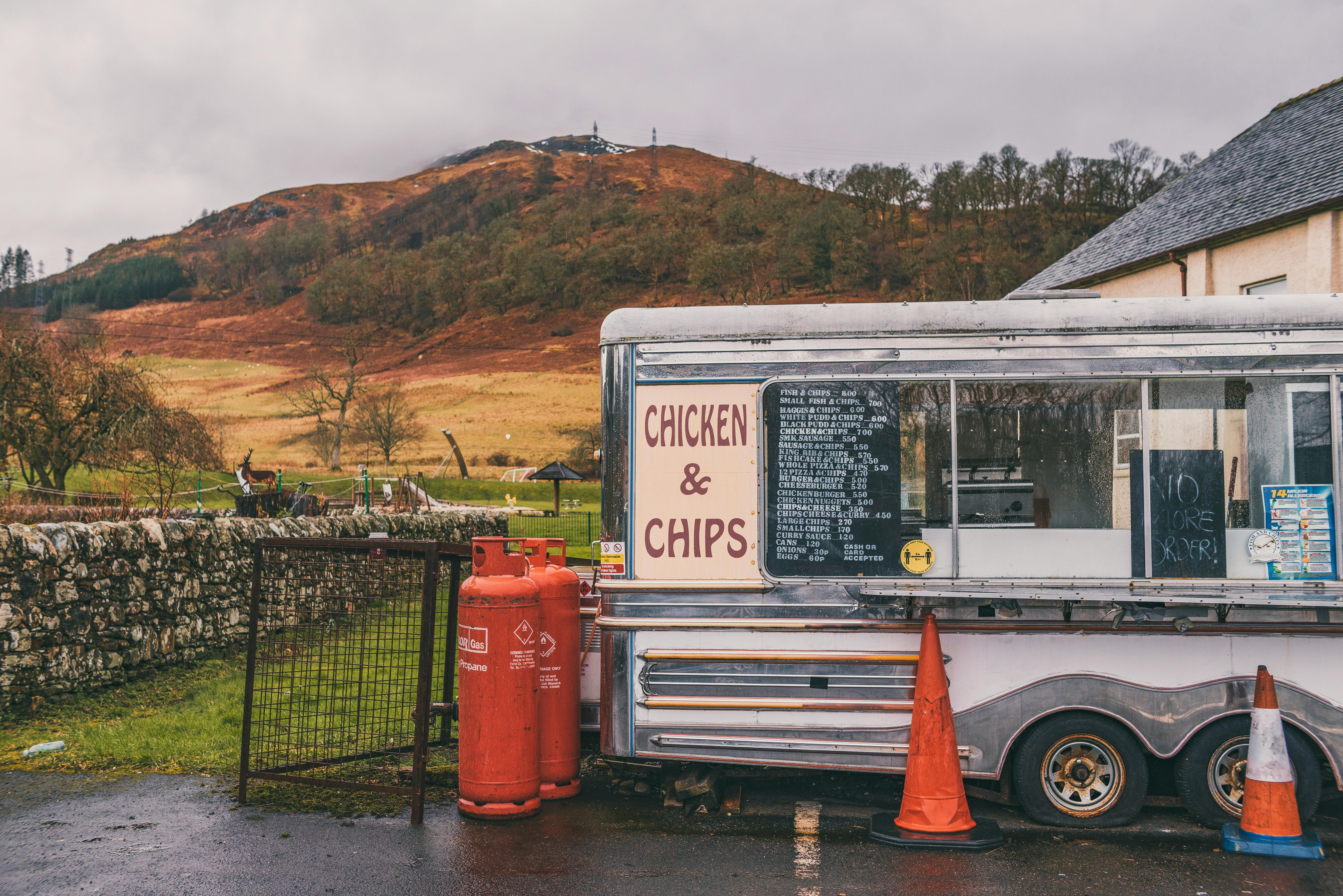 Roadside chicken and chips van beside a rural road with hills in the background on an overcast day
